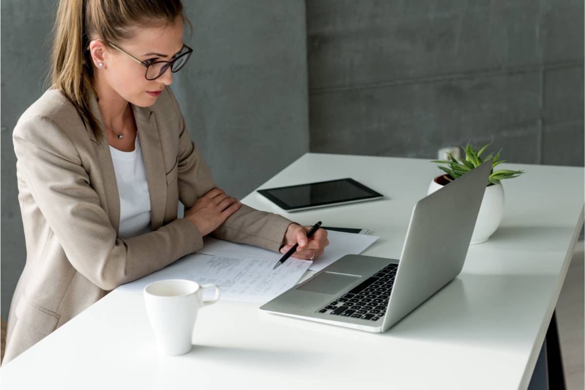 agilux-erp-avantages-pour-gestion-entreprise Femme d'affaires assise à un bureau en train de gérer son entreprise depuis son ERP