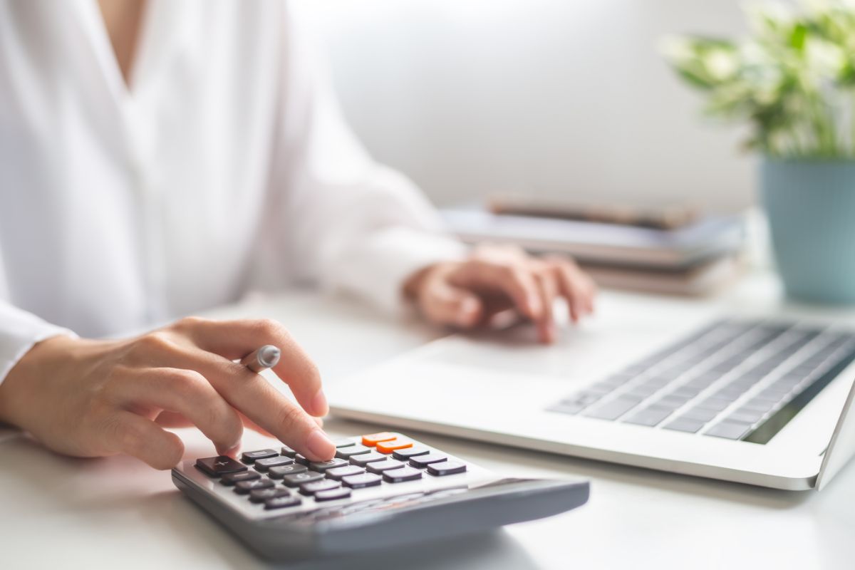 Femme entrepreneuse utilisant une calculatrice pour vérifier la rentabilité de ses projets