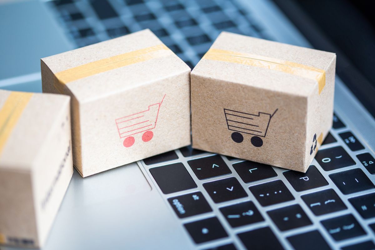 agilux-e-commerce-erp-mercator Trois petites boites en carton sur un clavier d'ordinateur représentant l'achat sur un e-commerce