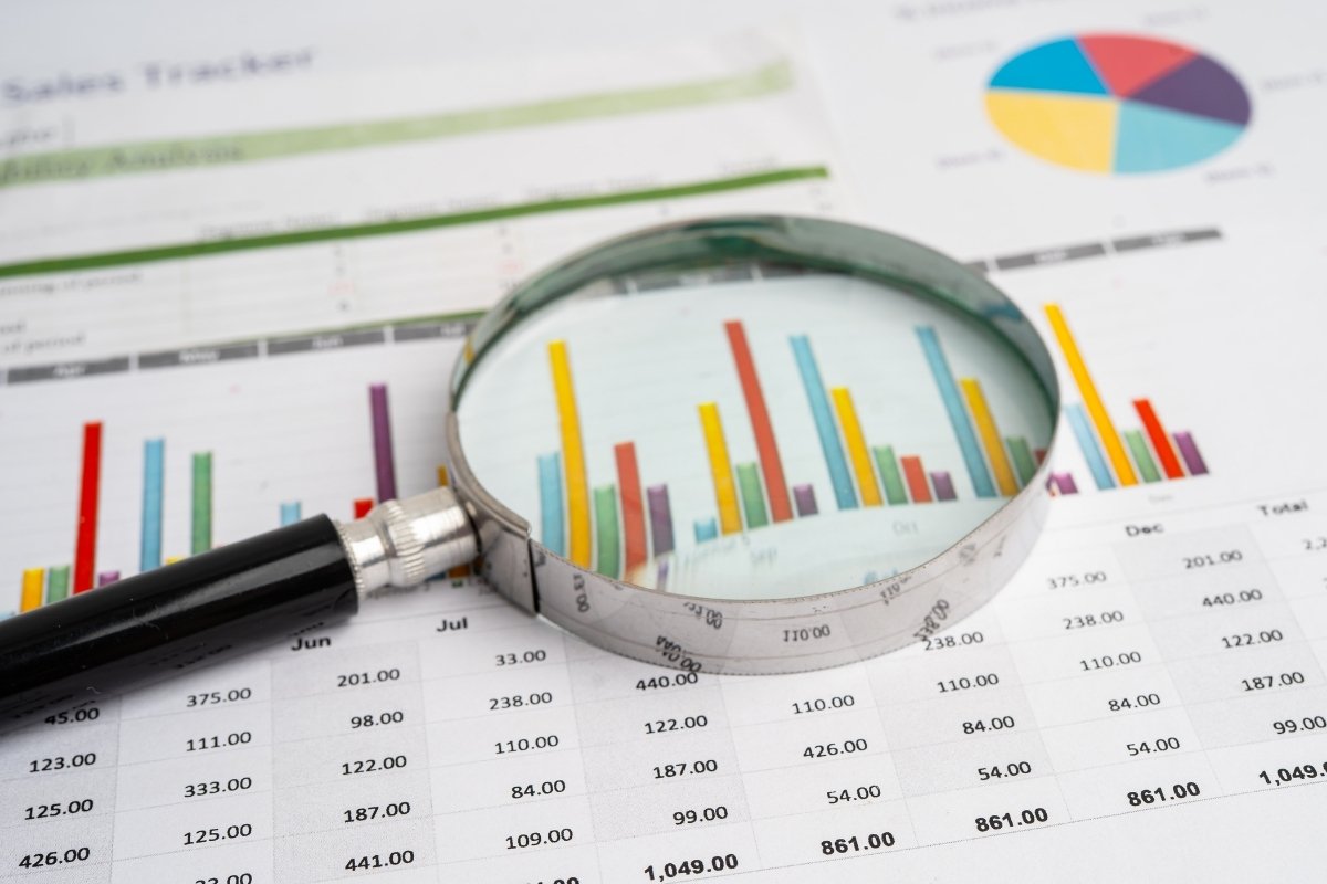 Tableau excel en papier sur un bureau avec une loupe pour zoomer sur les chiffres