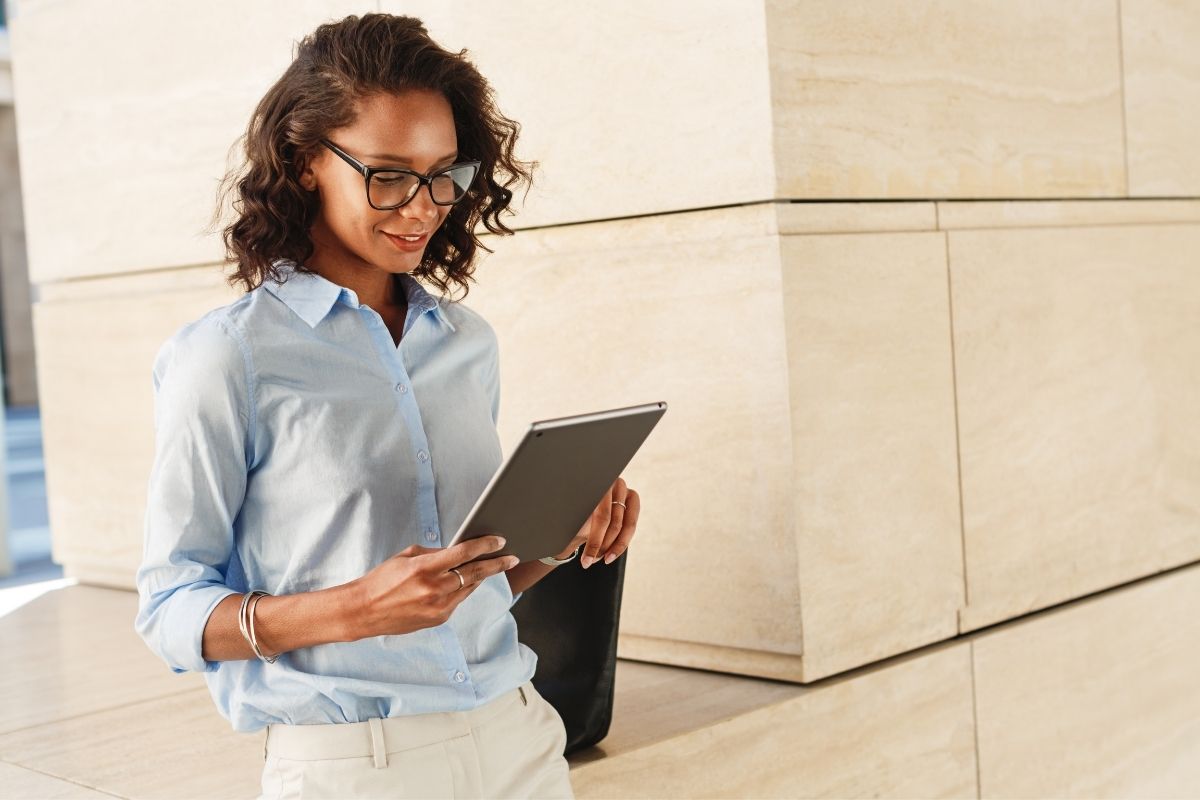 Femme commercial tenant une tablette en main lors d'un déplacement pour renseigner des données client