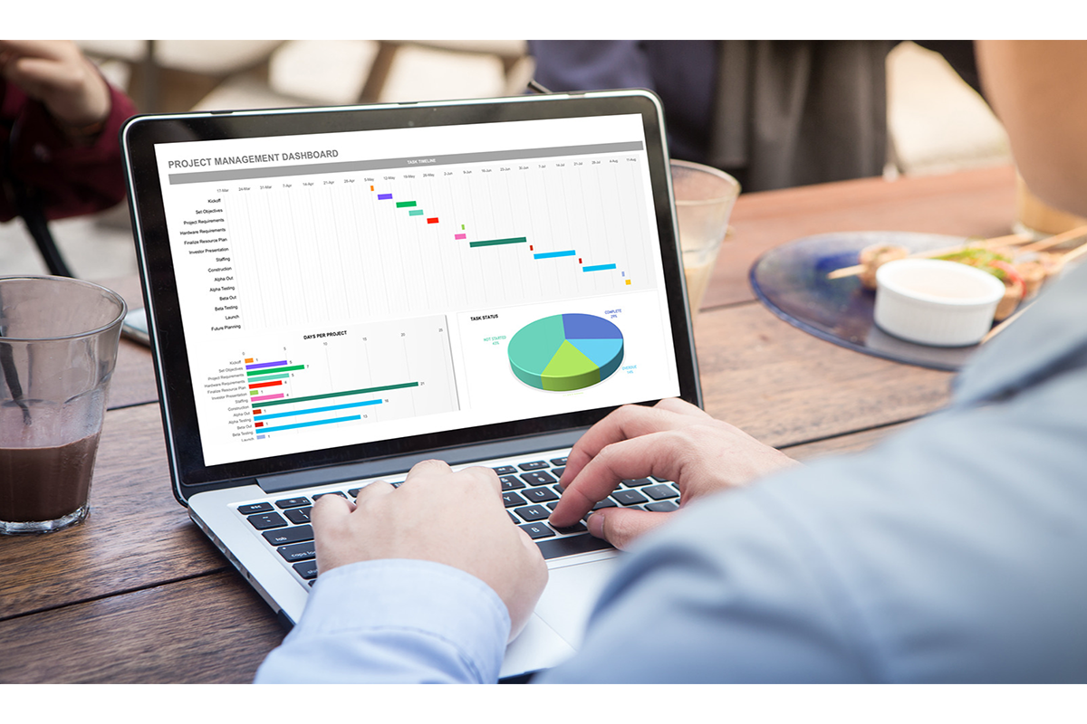 un homme qui regarde sur son pc portable son projet management dashboard